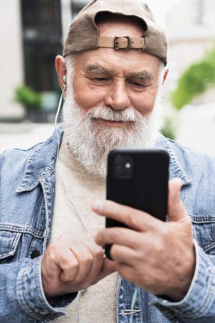 退休在城市里 带着智能手机的老人在户外男性城市老年
