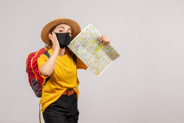 面具正面图年轻的旅行者背着红色的背包举着地图人旅游背包