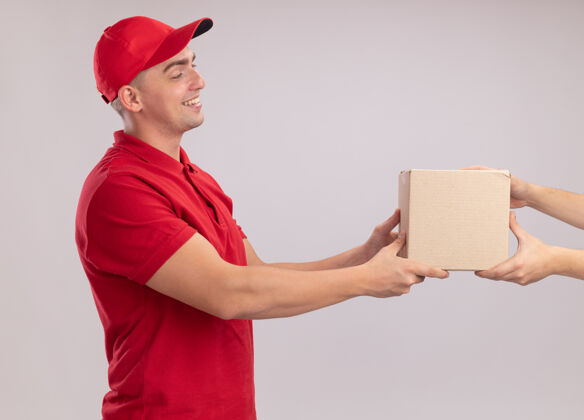 衣服面带微笑的年轻送货员穿着制服 拿着送帽盒 把客户隔离在白墙上感觉脸人
