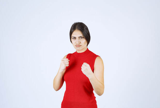 员工穿红衬衫的女孩展示她的拳头和力量强壮力量女性