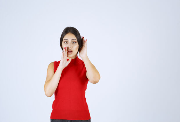 人类穿红衬衫的女孩指着自己的嘴 要求安静成人年轻人姿势
