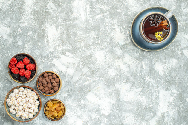 不同的顶视图一杯茶与不同的糖果上的白色空间关闭糖垃圾