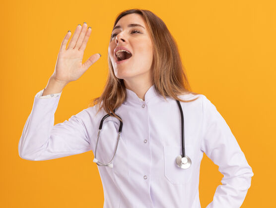 壁板高兴地看着身边年轻的女医生穿着医用长袍 用听诊器呼唤隔离在黄色墙上的人年轻人人脸