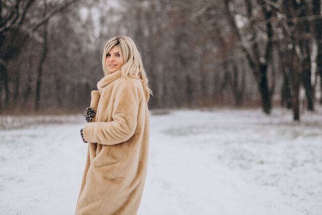 公园穿着冬衣的美女在满是雪的公园里散步冒险波西米亚探索