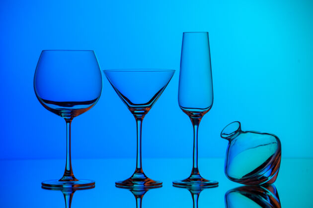 玻璃杯正面近距离的各种空玻璃高脚杯站在蓝色的表面水晶葡萄酒酒杯