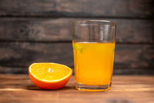 冷的前视图新鲜的橙汁在一个玻璃服务与薄荷和橙黄在一个木桌上刷新木头酒精