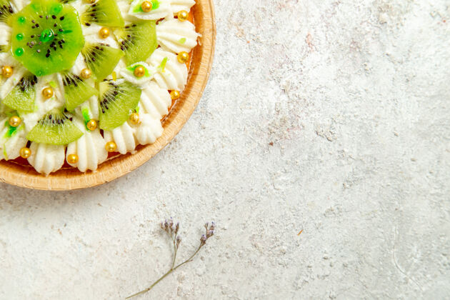 晚餐俯瞰美味的猕猴桃甜点 白色奶油和切片水果放在白色桌面上甜点蛋糕奶油水果热带景观美食食物