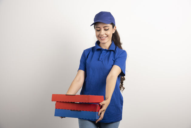 披萨年轻的女信使拿着一纸板披萨和剪贴板女孩剪贴板女人