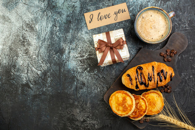 煎饼俯瞰一杯咖啡和新鲜美味的早餐美丽的礼品盒煎饼croissant在黑暗的背景坚果顶部咖啡