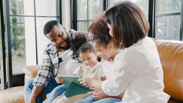 手机年轻的美国黑人家庭和女儿在家里使用平板电脑很开心互联网非洲活动