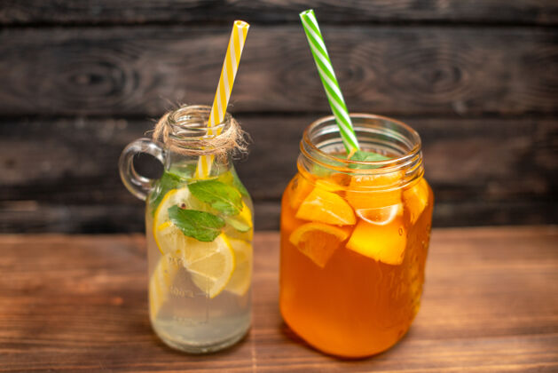果汁侧视图新鲜排毒水和果汁服务与管上的棕色背景管蜂蜜健康