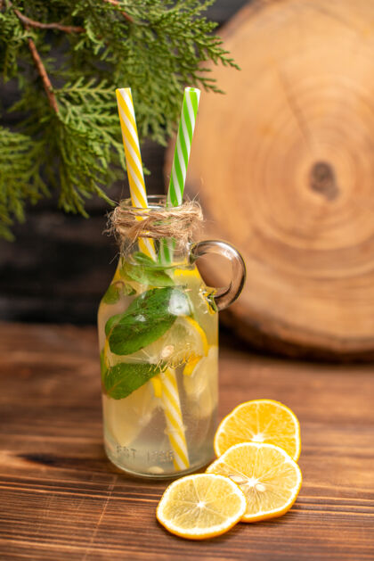 水果前视图的新鲜排毒水在一个玻璃与管和柠檬酸橙在木桌上服务冷木头冰