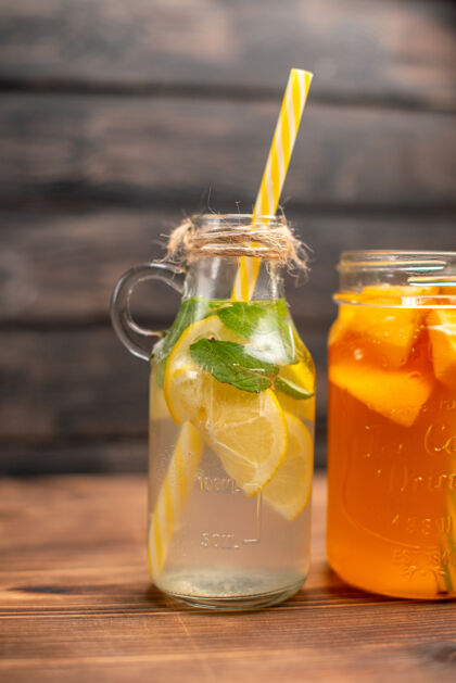 果汁新鲜排毒水和果汁的垂直视图 在左边的棕色背景上有管子酒精液体蜂蜜