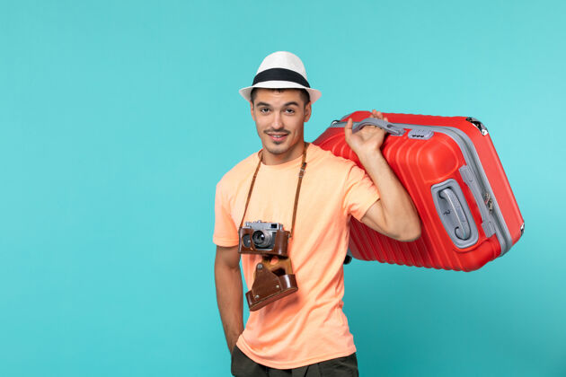 旅行带着红色手提箱和蓝色相机的度假男人人旅行时尚