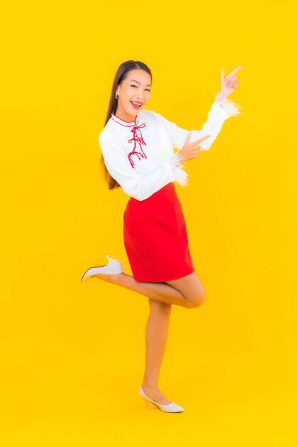 梦幻肖像美丽的亚洲年轻女子微笑在黄色的行动成功冷静卷曲