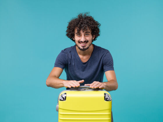 旅行带着黄色手提箱度假的男人在蓝色上感到快乐蓝感情厕所