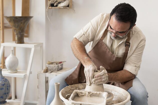 中镜头中在做陶器工艺手工艺术家
