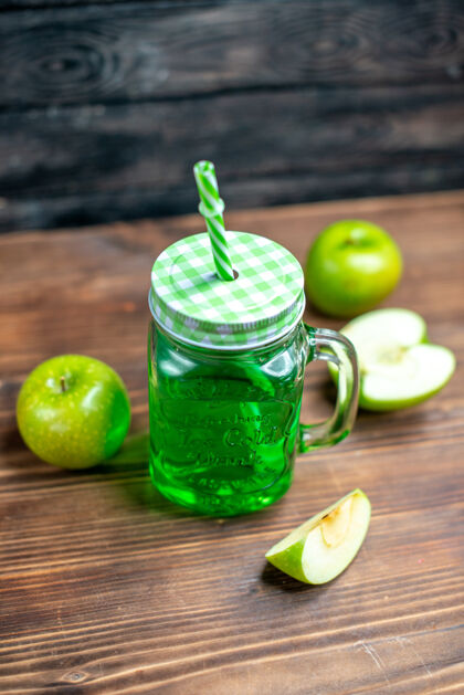 正面正面图绿色苹果汁内罐 木桌上放新鲜苹果 喝彩色水果照片新鲜办公桌饮食