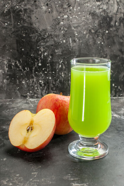 新鲜的苹果前视图新鲜的苹果与绿色的苹果汁对一个黑暗的果汁照片醇厚的水果成熟的颜色树果汁液态的玻璃杯