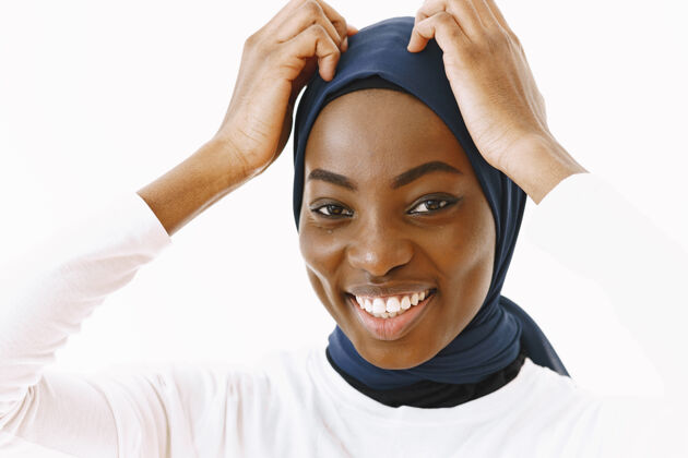 面纱可爱满足的宗教女子头像 面带温和微笑 皮肤黝黑健康 头上戴围巾隔离在白色背景上东方非洲