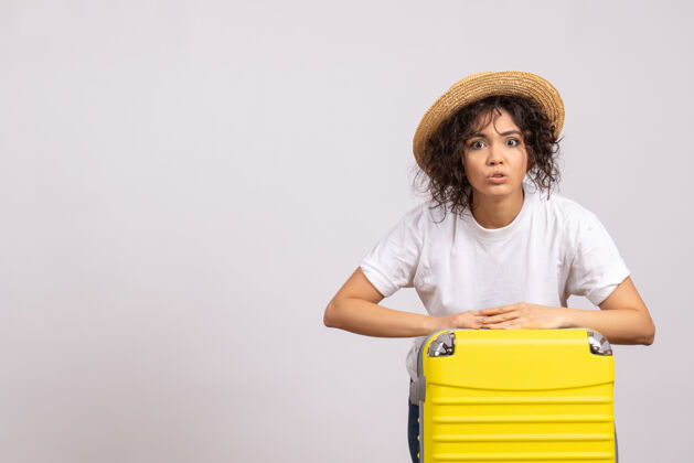 旅行正面图：年轻的女性 带着黄色的包 准备乘坐白色背景的度假旅行旅游飞机旅行年轻的女性飞行航行
