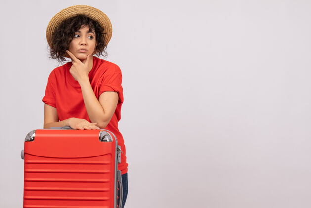 年轻女性正面图年轻女性带着红包准备乘坐白色背景飞机旅行休息度假阳光色旅游航班远航旅行微笑人