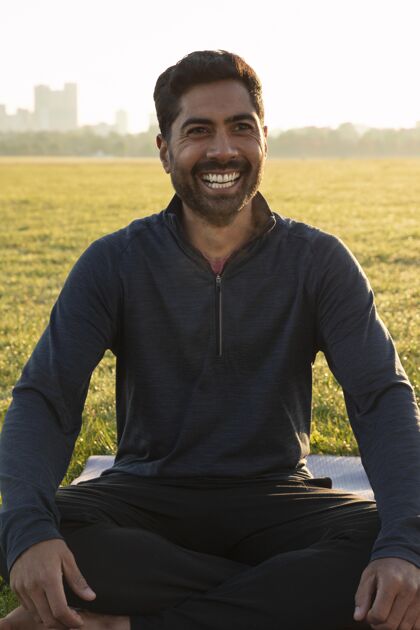 心灵笑脸人在瑜伽垫上冥想的正面图冥想男性活动