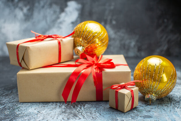 庆祝前视图圣诞礼物与红色蝴蝶结和玩具绑在浅色深色新年照片节日彩色礼物圣诞圣诞节前面盒子