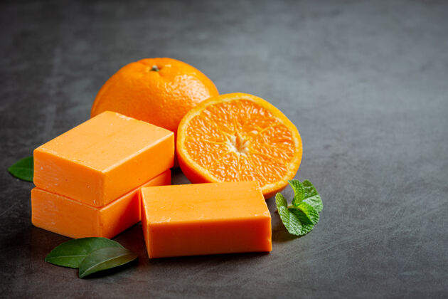 柑橘橙色肥皂与新鲜的橙色在黑暗的背景美容产品香水