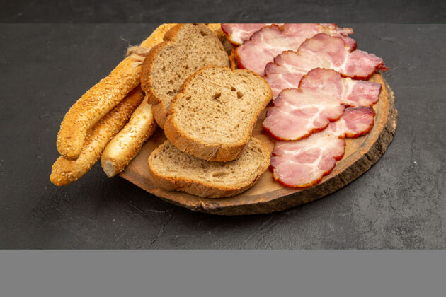 正餐正面图新鲜切片火腿 面包片和面包包 深色食物肉面包房前面小面包