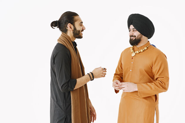 伙伴关系穿着传统服装的巴基斯坦男人和印度男人朋友们在白色背景下交谈 与世隔绝国家间的友好放松印度男人
