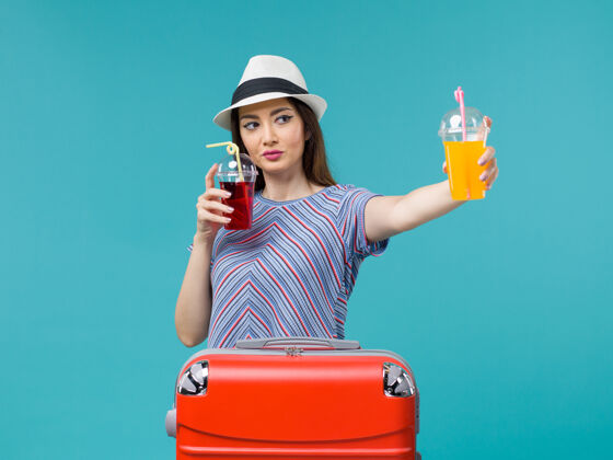 女人度假的女人拿着蓝色的新鲜饮料抱肖像航程