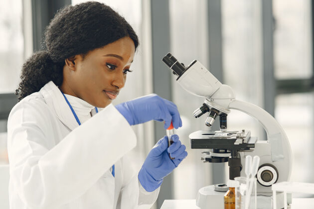生物学家医学博士 一个拿着显微镜工作的女孩年轻的女科学家在做疫苗研究物理医院创新