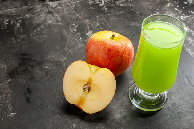 前前视图新鲜成熟的苹果与绿色的苹果汁对深色醇厚的果汁树照片的颜色木瓜苹果桃