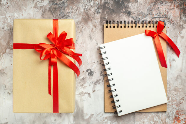 记事本顶视图圣诞礼物与红色蝴蝶结笔记本绑在白色照片假日彩色新年礼物圣诞信封庆祝礼物