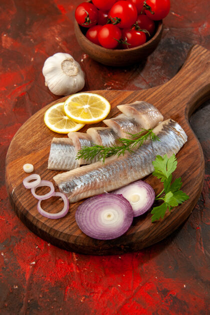 健康正面图：新鲜的鱼片 洋葱圈和西红柿 深色肉类小吃 彩色海鲜食物肉蔬菜