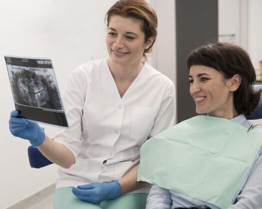 工人女病人和牙医一起看牙齿的X光片病人职业女性