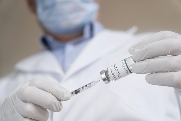 解毒剂男医生拿着带注射器的疫苗瓶治疗注射注射