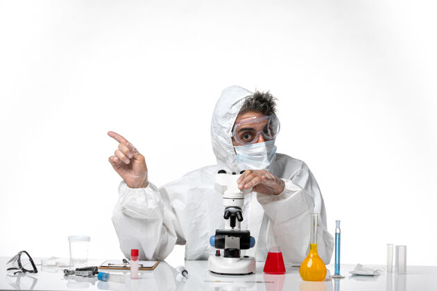 外套一个穿着防护服 戴着面罩的男医生用显微镜在一辆白色的车上成人大流行实验室外套