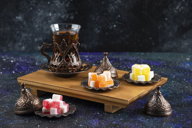 美味木板上放着土耳其美食的茶具盘子糖果五颜六色