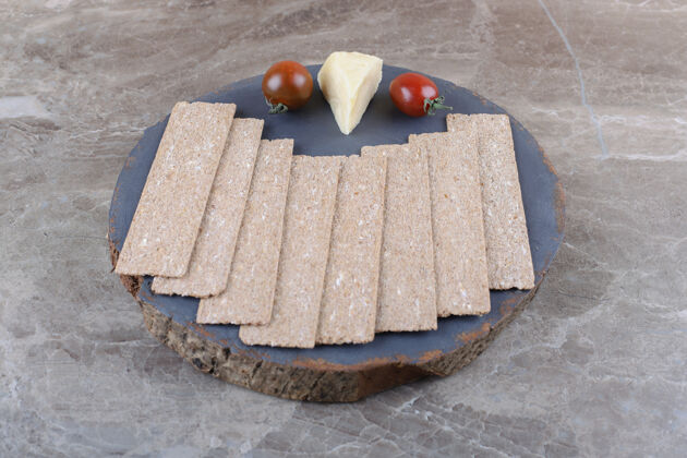 年糕一堆酥皮面包 西红柿 奶酪放在木板上 放在大理石表面配料天然健康