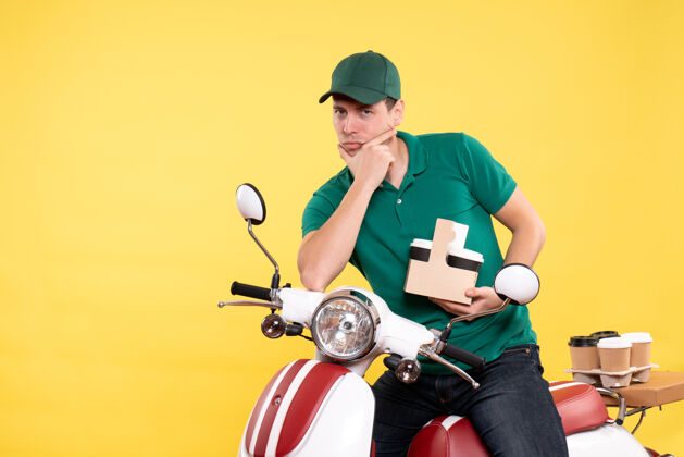 摩托车正面图身着绿色制服的年轻男性信使 咖啡色系黄色输送机速度工作