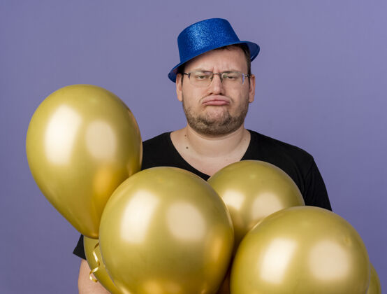 不愉快戴着眼镜 头戴蓝色派对帽 手持氦气球的未获释成年斯拉夫男子聚会紫色帽子