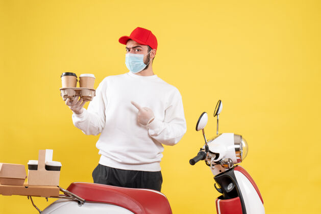 摩托车戴着面具的男信使拿着黄色的咖啡帽子黄色咖啡