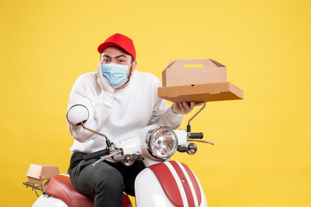 头盔戴着面具的男快递员拿着黄色的快递食品摩托车食物车辆