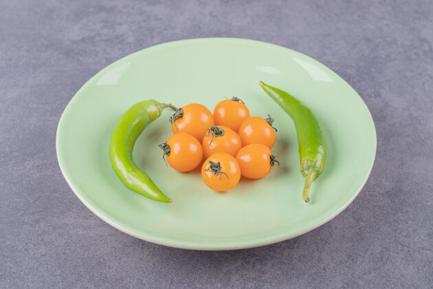 胡椒一个有樱桃黄色西红柿和辣椒的绿色盘子香料辣番茄