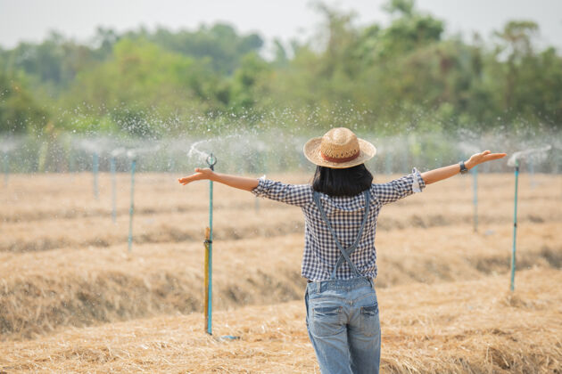 活动亚洲年轻的女农民戴着帽子站在田里 走在田里的妇女来视察农业园植物生长概念生态 运输 清洁空气 食品 生物制品教育人乡村