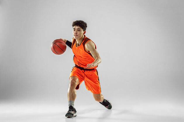 健身年轻的篮球队员穿着运动服训练 在运动中练习 在运动中奔跑隔离在白墙上活跃广告空间年轻