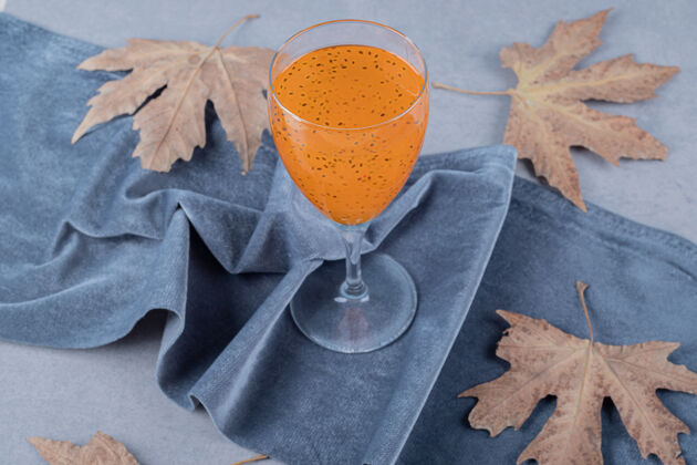 美味新鲜的自制果汁 灰色表面有装饰性的叶子鸡尾酒潘趣酒深色