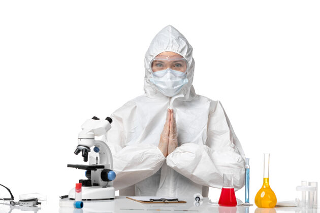 人正面图年轻女医生穿着防护服带着口罩坐在白色背景上病毒大流行飞溅covid-药年轻女医生医生